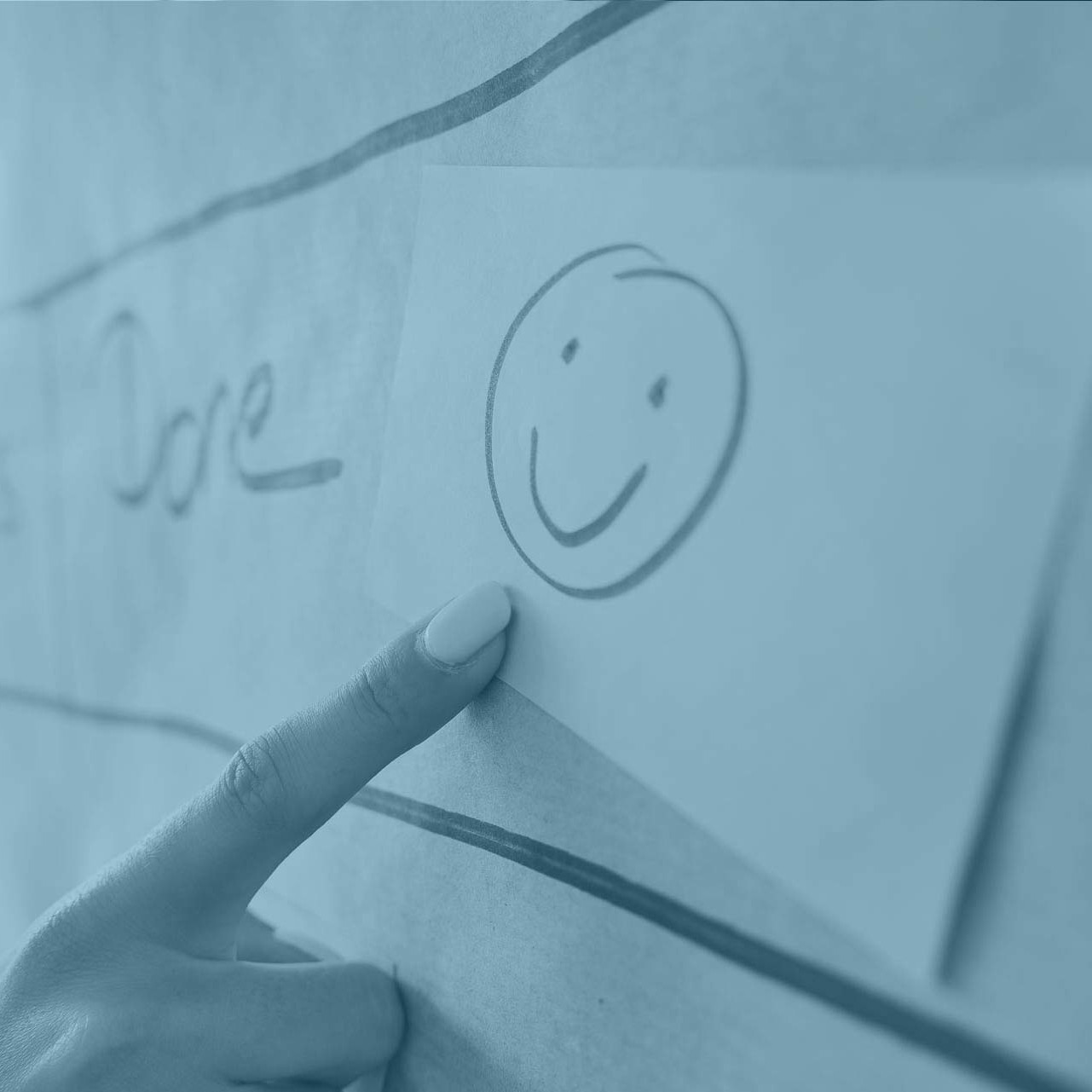 Finger zeigt auf Smiley an Pinnwand